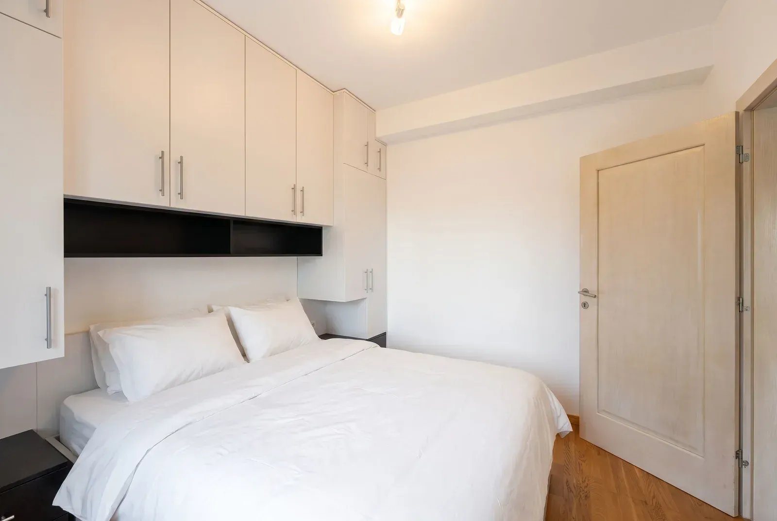 Bright bedroom with a double bed and built-in wardrobes.