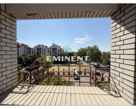 View from the balcony overlooking surrounding buildings and greenery. - image 19
