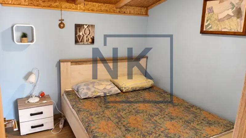 A bedroom with a double bed, a nightstand, and blue walls.