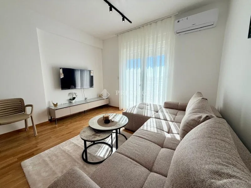 Bright living room with sofa, coffee table, and TV.