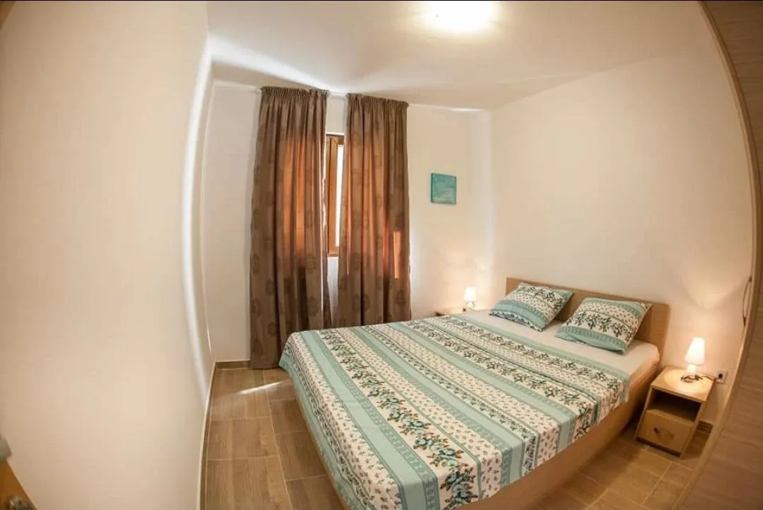 Furnished bedroom with a double bed and a window.