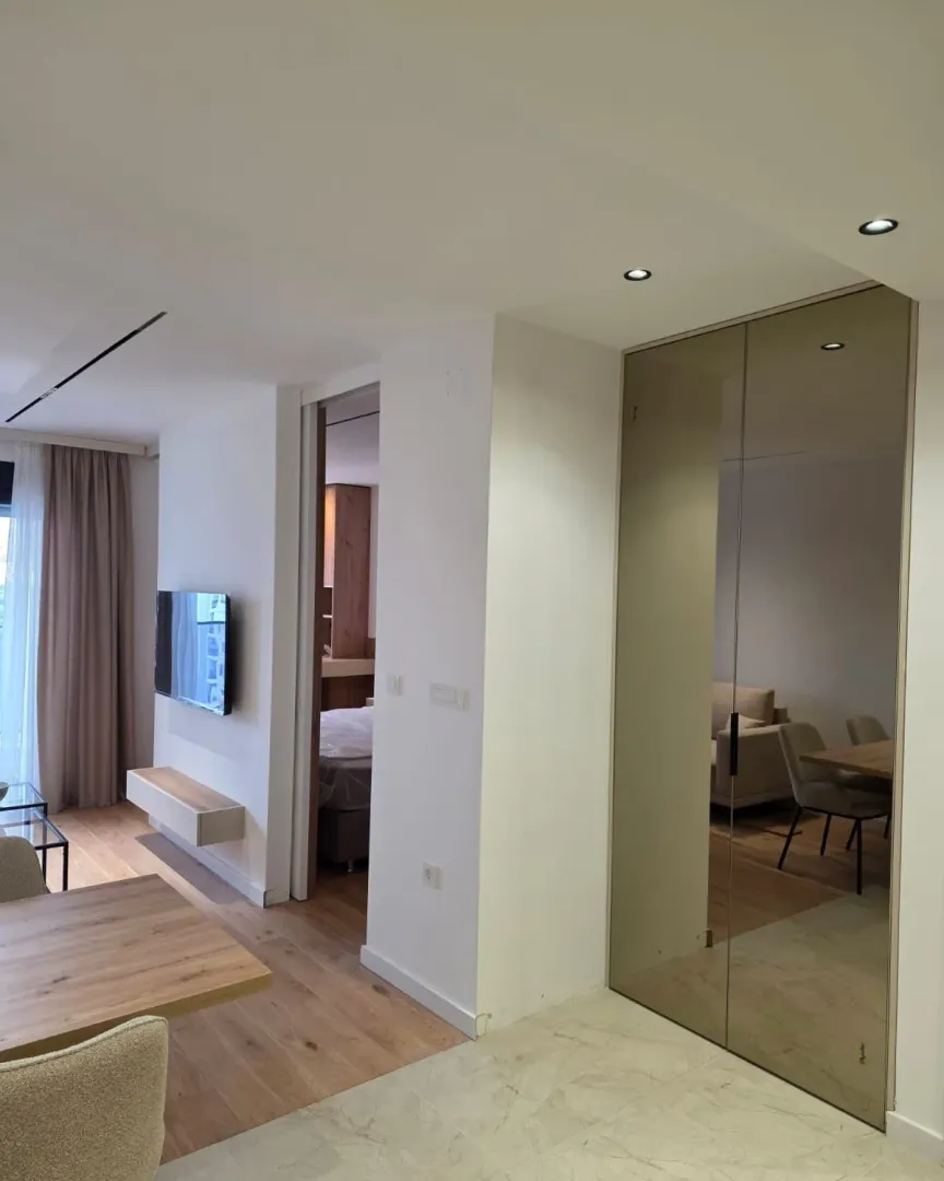 Living room with dining area and a mirrored built-in wardrobe.