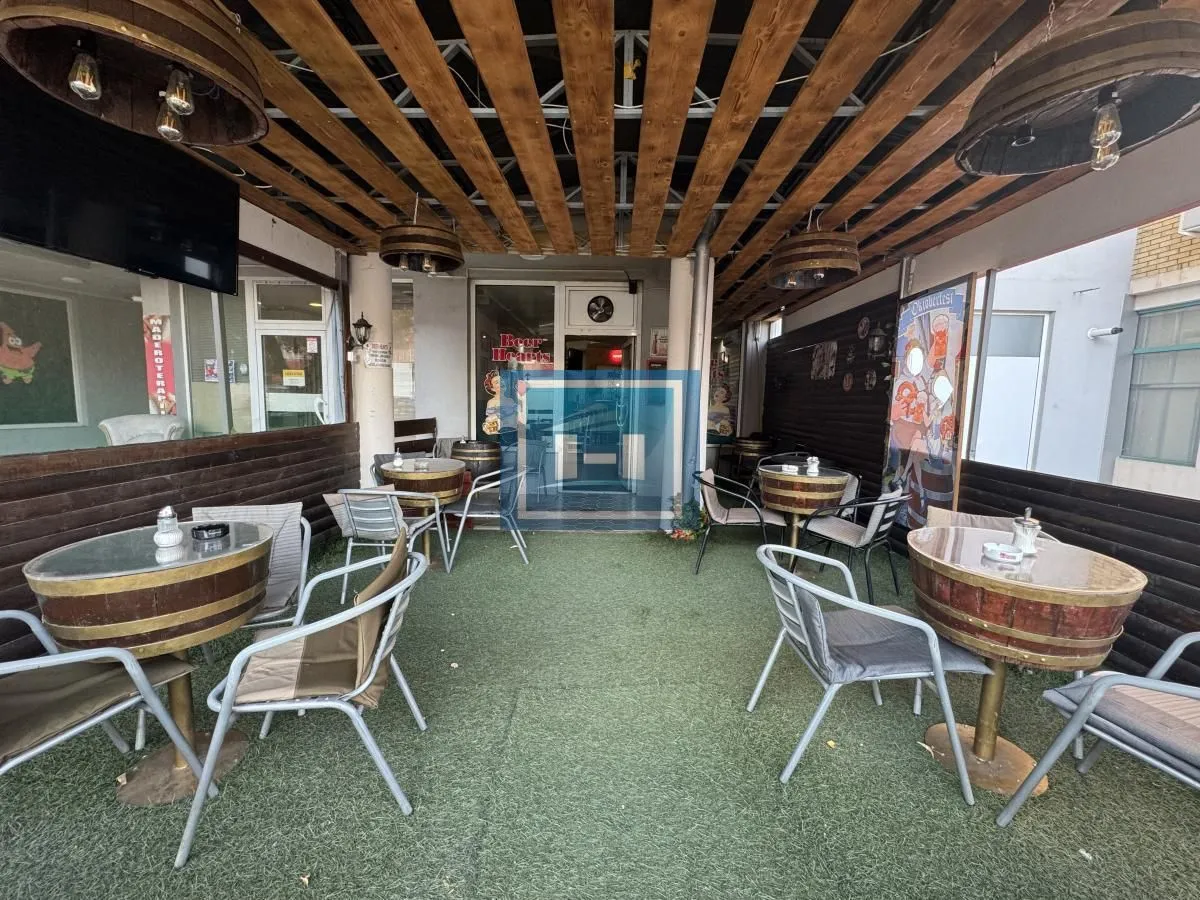 Covered terrace with tables and chairs furnished in a hospitality style.