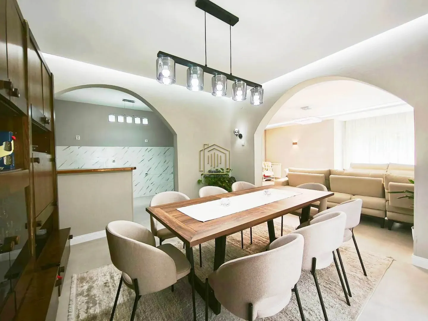 Dining area with a wooden table and chairs, connected to the living room and kitchen.