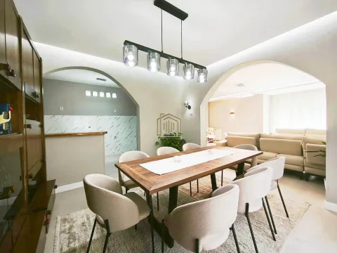 Dining area with a wooden table and chairs, connected to the living room and kitchen. - image 3