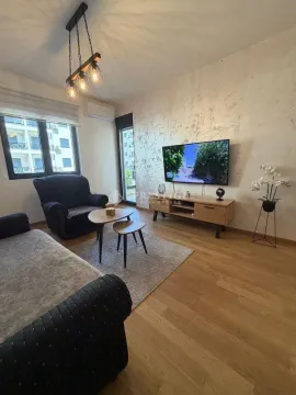 Living room with sofa, TV, and coffee table. - image 2