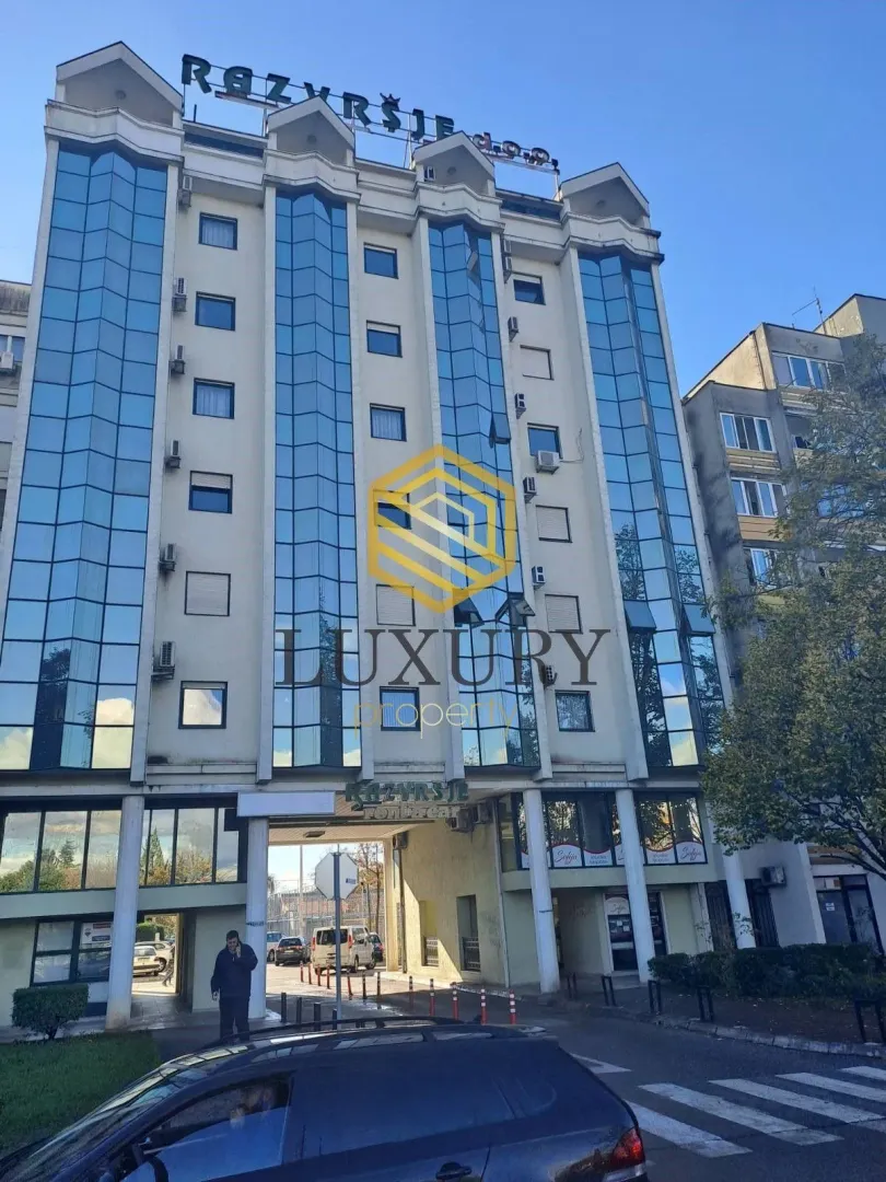Exterior view of a multi-story residential and commercial building with a glass facade.