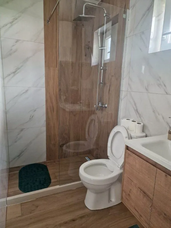 Modern bathroom with a walk-in shower and white ceramic tiles.