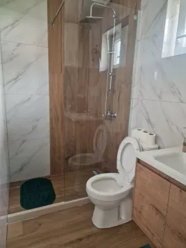 Modern bathroom with a walk-in shower and white ceramic tiles. - image 8