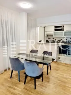 Dining area with a table and chairs and a view of the kitchen. - image 2