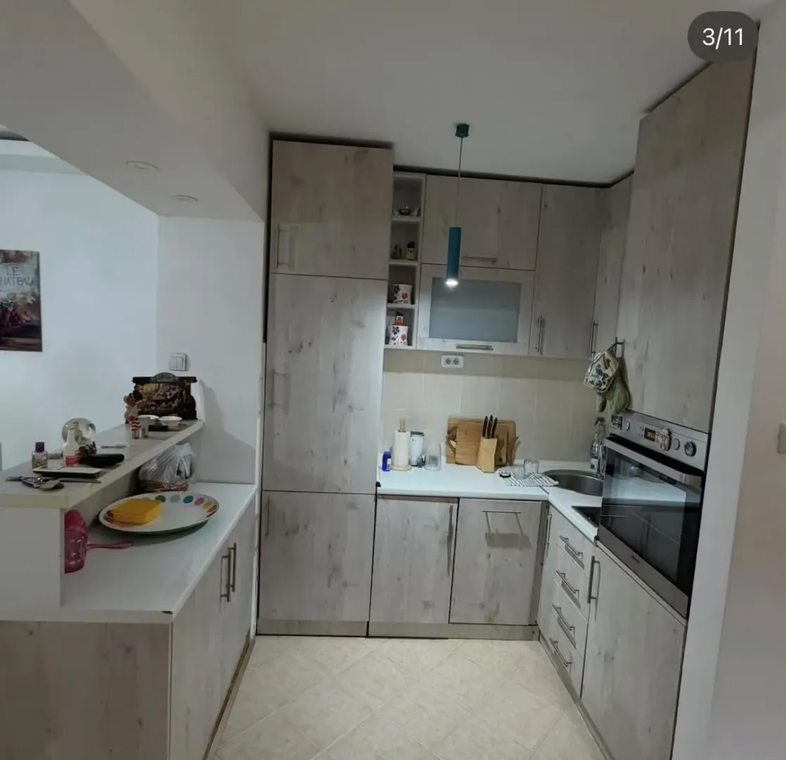 Smaller kitchen with wooden elements and a built-in oven.