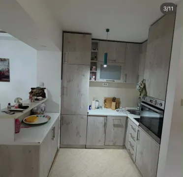 Smaller kitchen with wooden elements and a built-in oven. - image 3