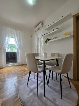 Dining area with a table, four chairs, and wall shelves. - image 2