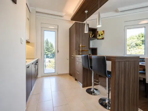 Moderna kuhinja sa šankom i drvenim elementima. - image 9