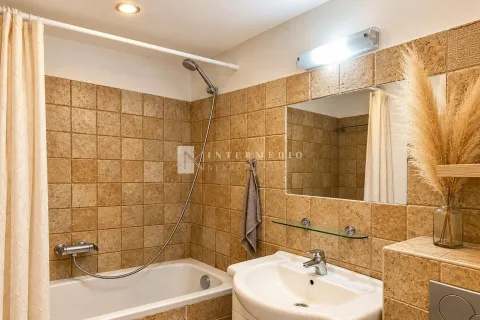 Kupatilo obloženo bež pločicama sa kadom i umivaonikom. - image 11
