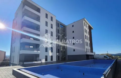 Exterior view of a modern residential building with a swimming pool in the courtyard. - image 6