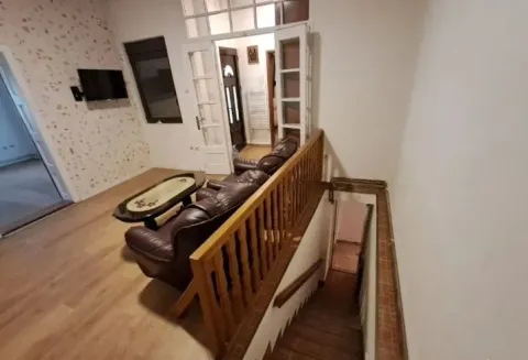 Dnevni boravak sa garniturom i stepeništem koje vodi u donji nivo. - image 2