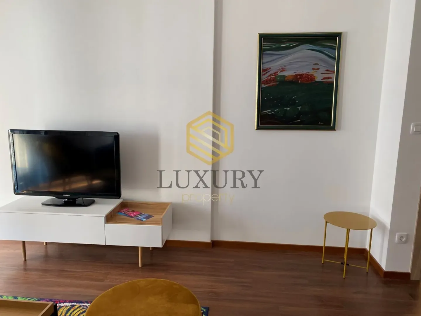 Living room with a TV cabinet and an artwork on the wall.