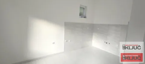 Unfurnished kitchen with white walls and grey wall tiles. - image 7