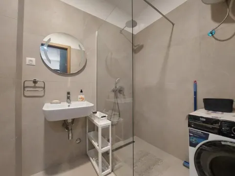 Modern bathroom equipped with a walk-in shower and washbasin. - image 16