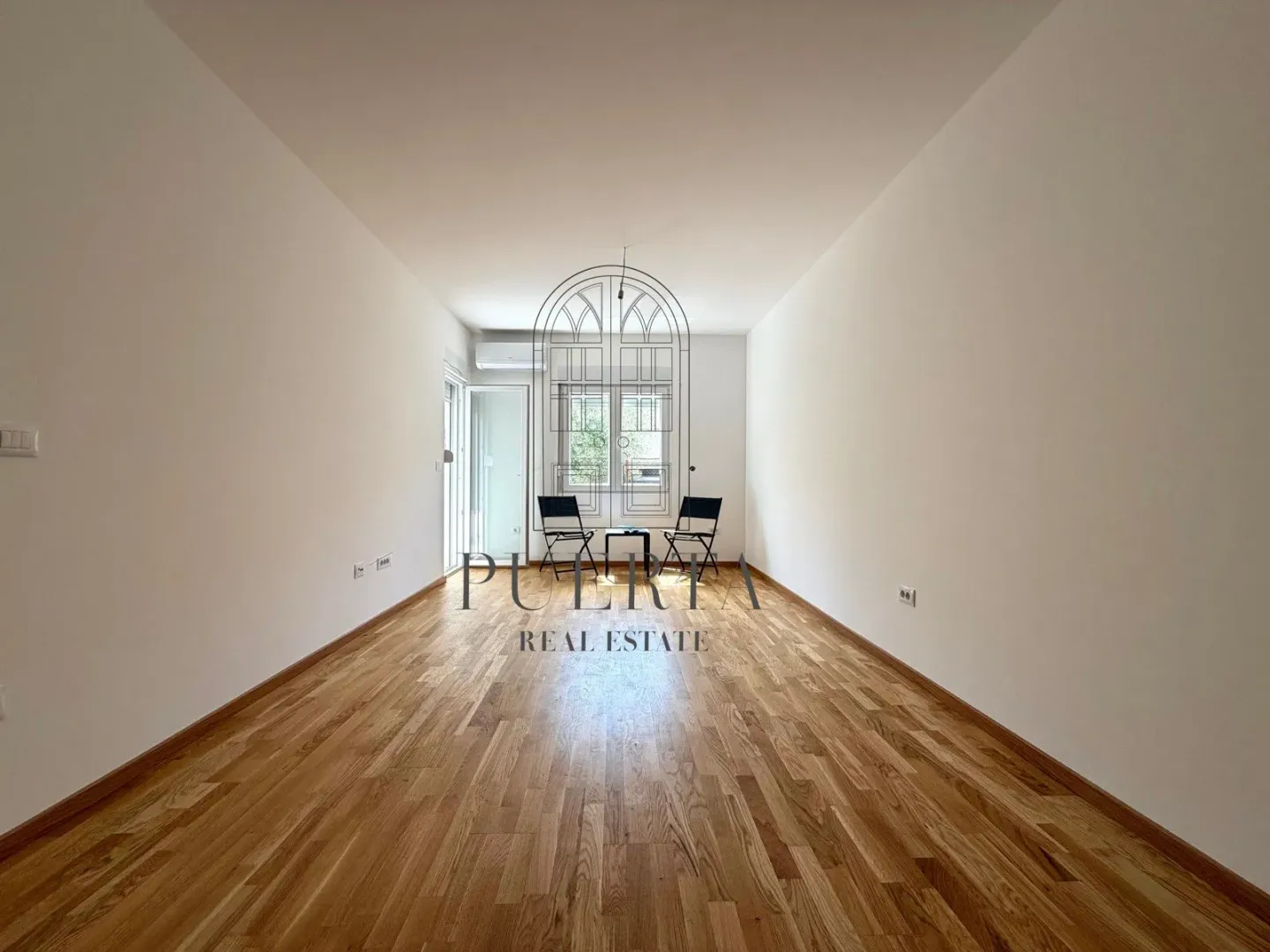 Empty room with hardwood floors and white walls.