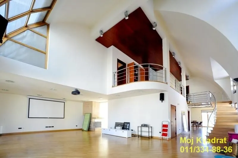 Spacious living room with high ceiling, gallery and staircase.