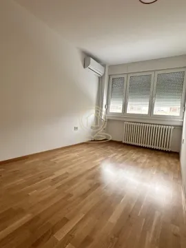Prazna soba sa drvenim podom, klima uređajem i prozorom sa roletnama. - image 16