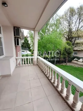 Spacious tiled terrace with balustrade and a view of the green courtyard. - image 7