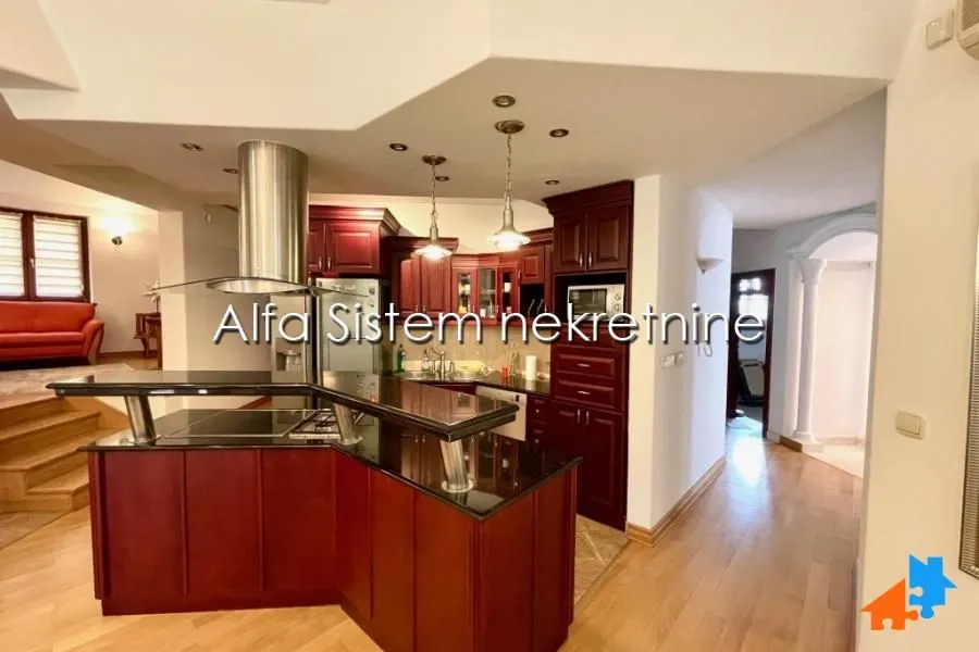 Spacious kitchen with dark wooden cabinets and a breakfast bar.