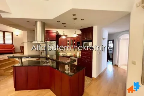 Spacious kitchen with dark wooden cabinets and a breakfast bar. - image 6