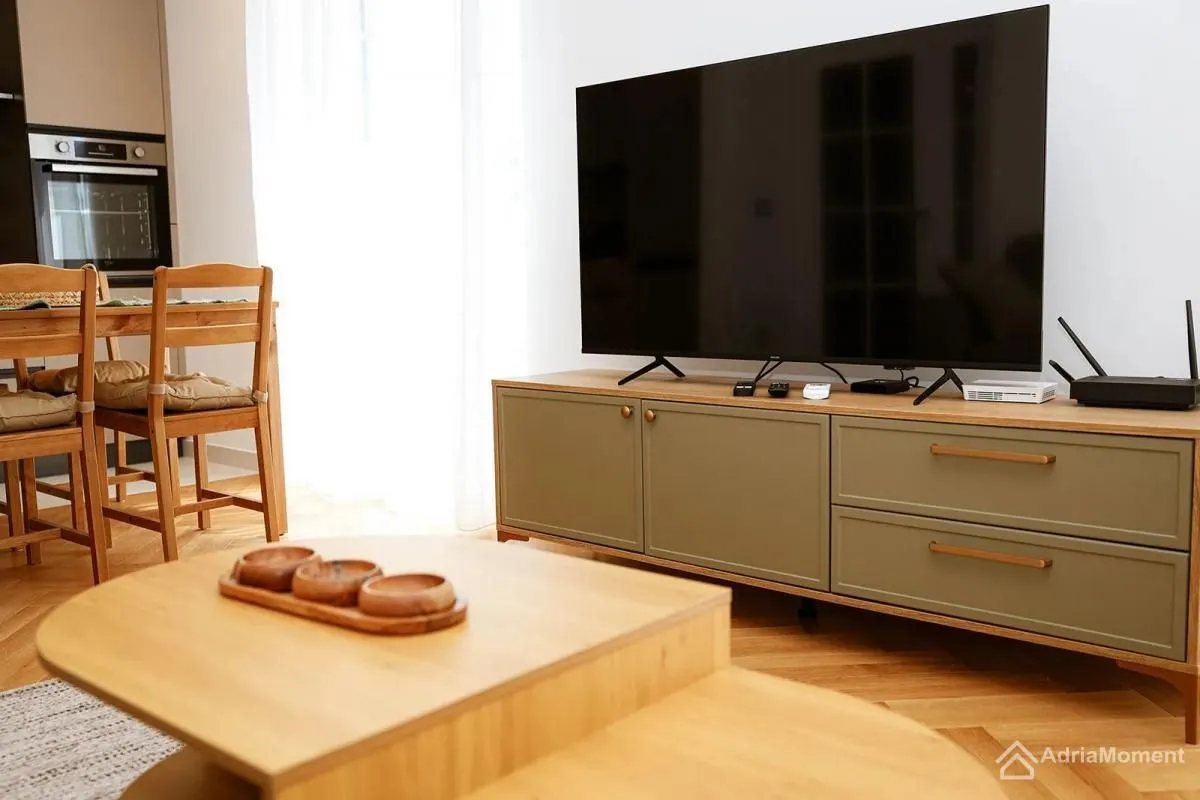 Dnevni boravak sa televizorom i komodom.