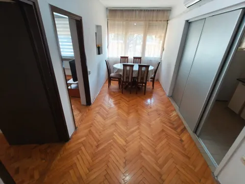 Dining area with a table and chairs, parquet flooring, and a window with curtains. - image 7