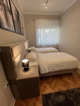 Bright bedroom with two single beds and modern nightstands. - image 10