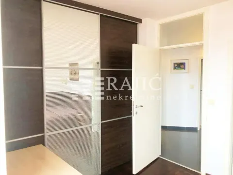 Interior of a bedroom with a large built-in wardrobe and an open door. - image 4