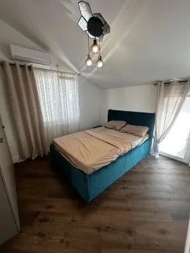 Uređena spavaća soba sa bračnim krevetom, drvenim podom i prozorima sa zavjesama. - image 2