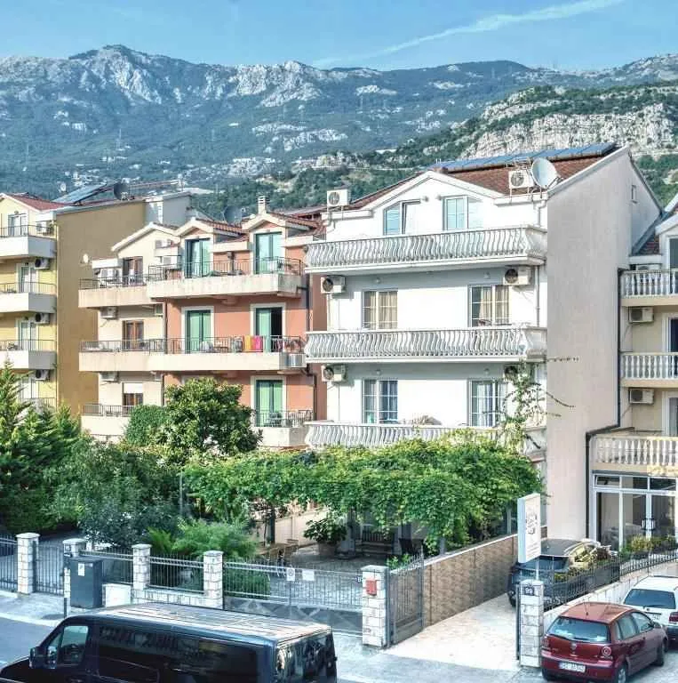 Pogled na spoljašnjost zgrade sa dvoriijem i planinama u pozadini.