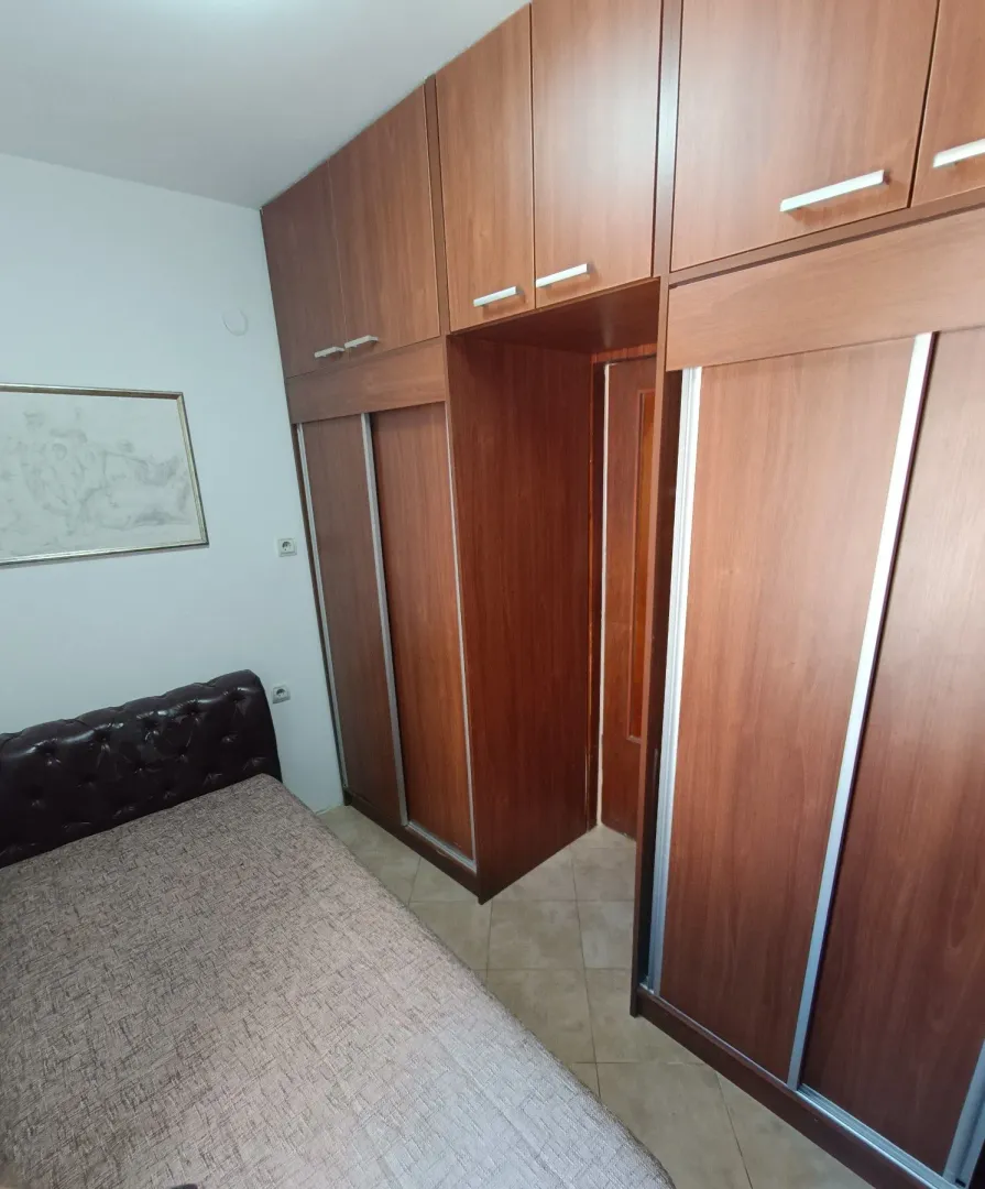Bedroom with large wooden closets and a bed.