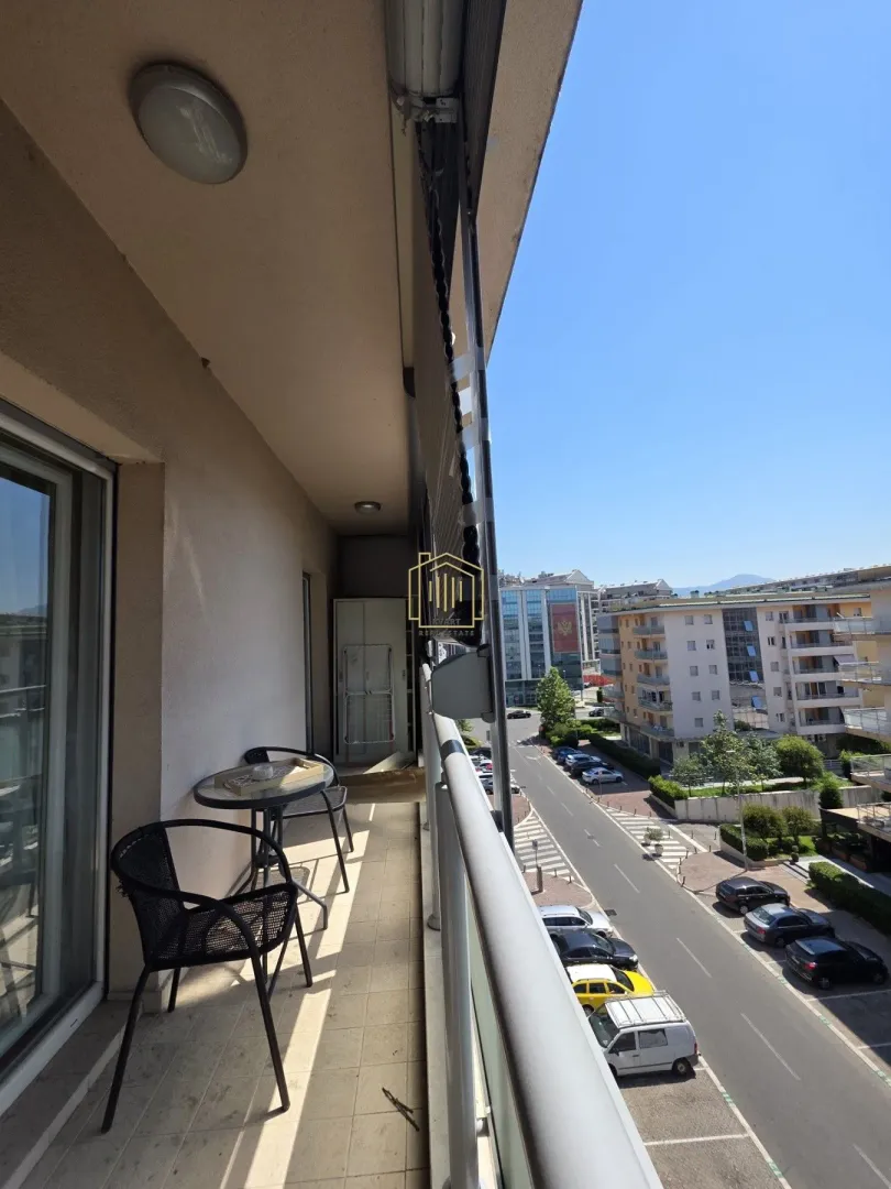 Long balcony with seating furniture and a street view.