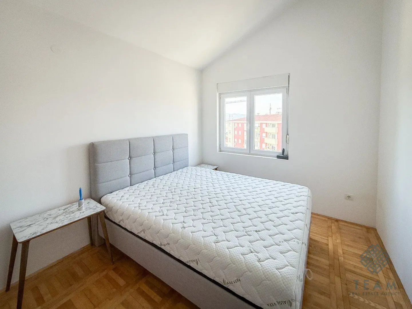 Spavaća soba sa bračnim krevetom i prozorom.