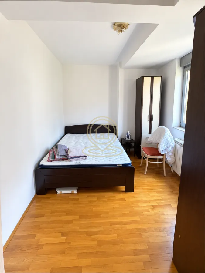 Smaller bedroom with a bed, wardrobe, and wooden flooring.