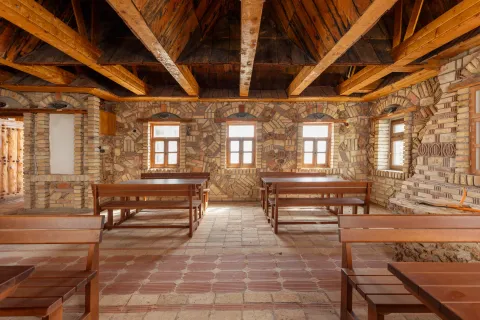 Spacious rustic room with wooden ceiling beams and stone walls. - image 27