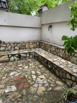 Popločano dvorište sa kamenim klupama i zidom. - image 7