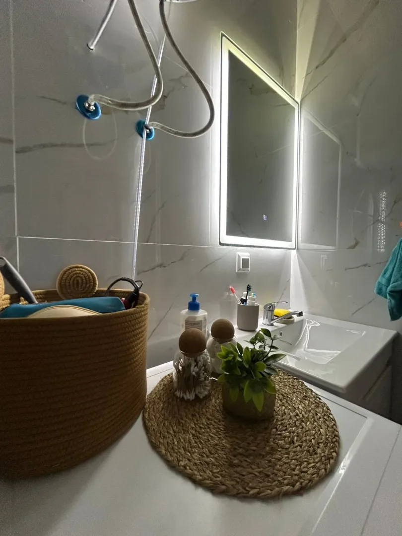 Modernly equipped bathroom with a washbasin and illuminated mirror.