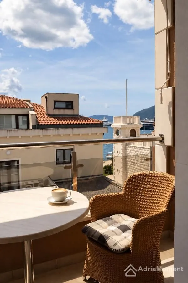 Namješten balkon sa stolom, stolicom i pogledom na more.