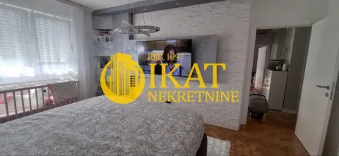 Nameštena spavaća soba sa krevetom, televizorom na zidu i dečijim krevetcem. - image 4