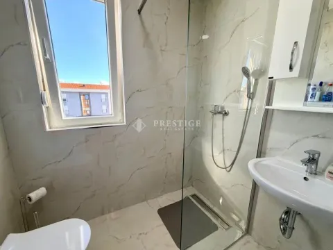 Modernly equipped bathroom with a walk-in shower and sink. - image 10