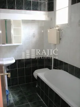 Manje kupatilo obloženo keramičkim pločicama sa kadom, toaletom i umivaonikom. - image 9