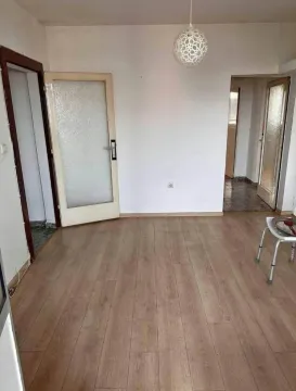 Prazna prostorija sa drvenim podom i bijelim zidovima. - image 2