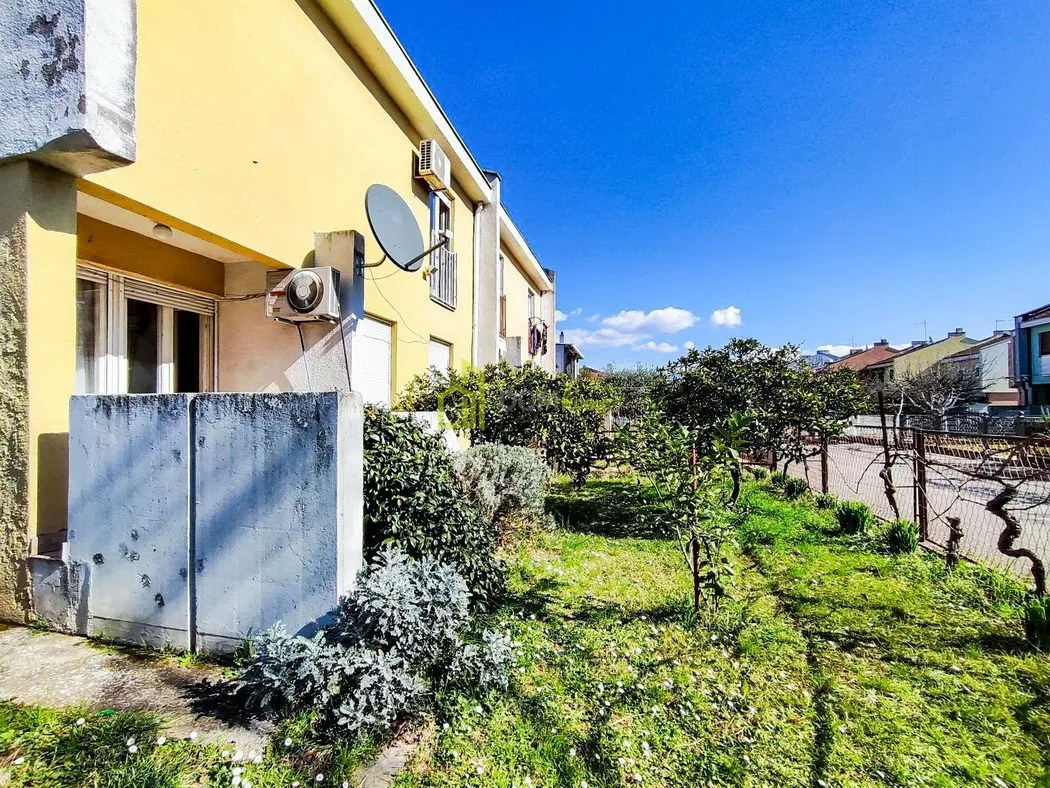 Pogled na dvorište i fasadu kuće sa uređenim zelenilom.