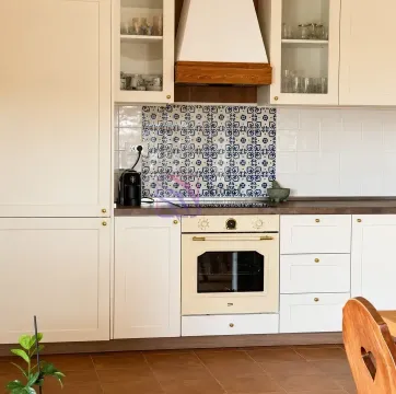 Kitchen with light-colored cabinets and a built-in oven. - image 8